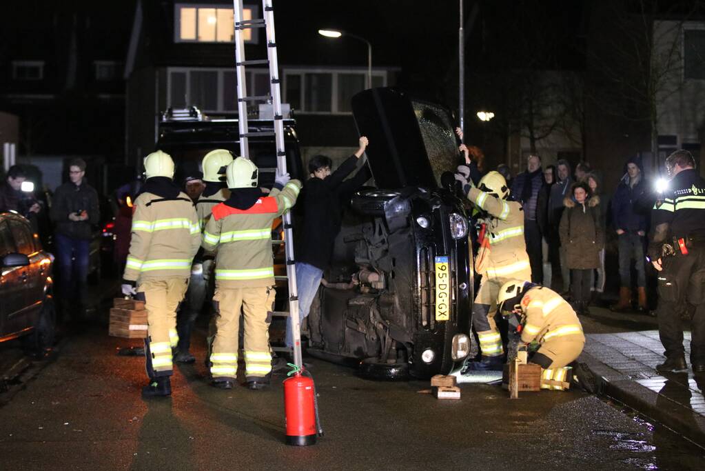 Bestuurster bekneld na auto op zijn kant