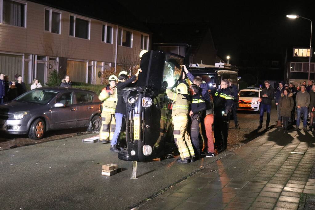 Bestuurster bekneld na auto op zijn kant