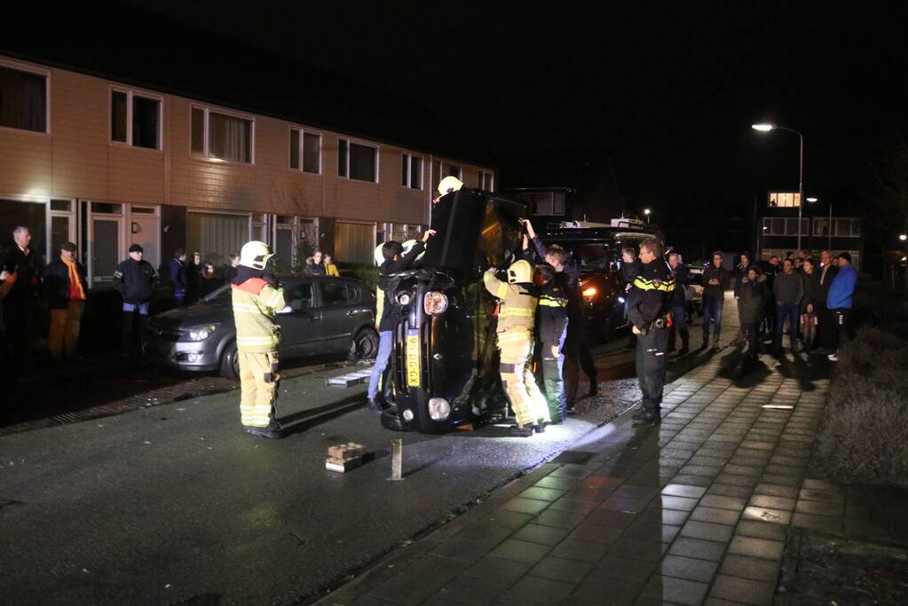 Bestuurster bekneld na auto op zijn kant
