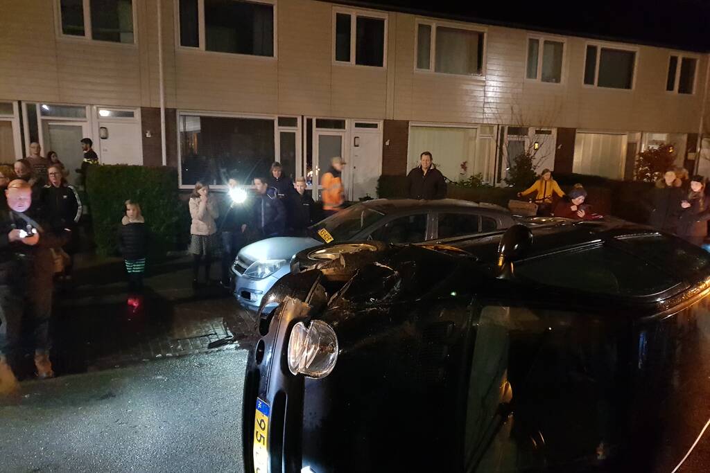 Bestuurster bekneld na auto op zijn kant