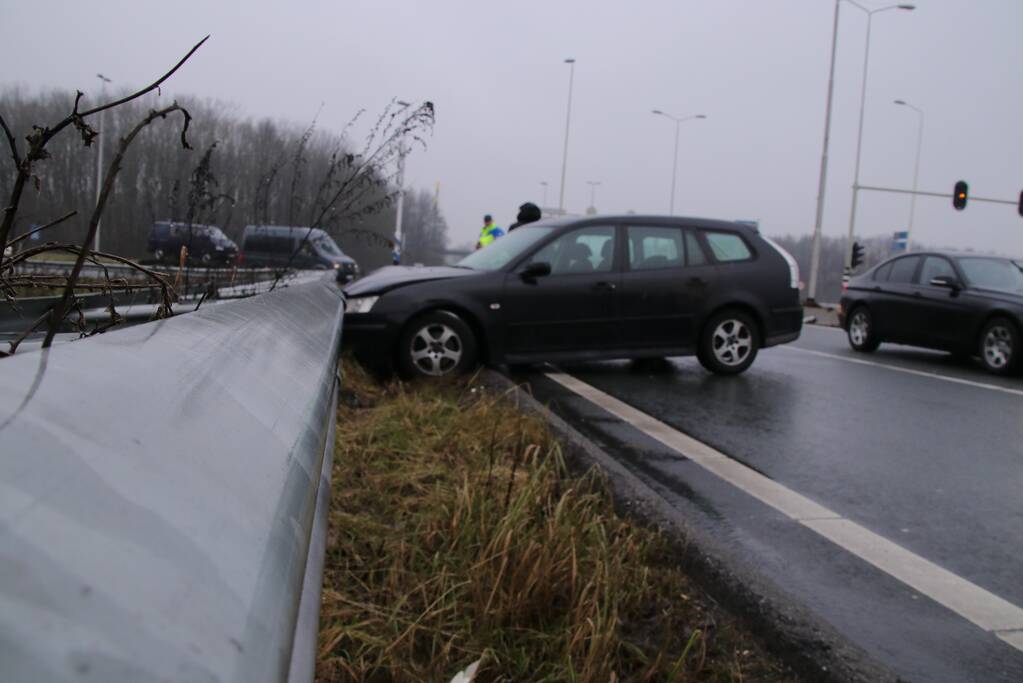 Auto raakt in slip knalt in vangrail