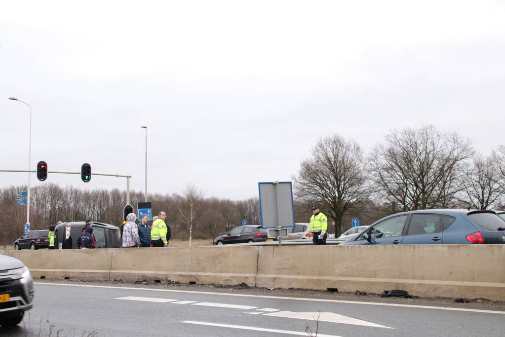 Auto vliegt over middengelijder en belandt op zijkant