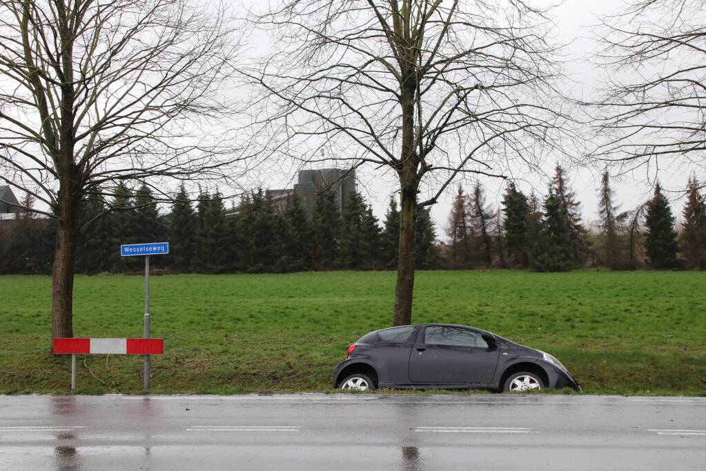 Auto schiet over kruising de sloot in