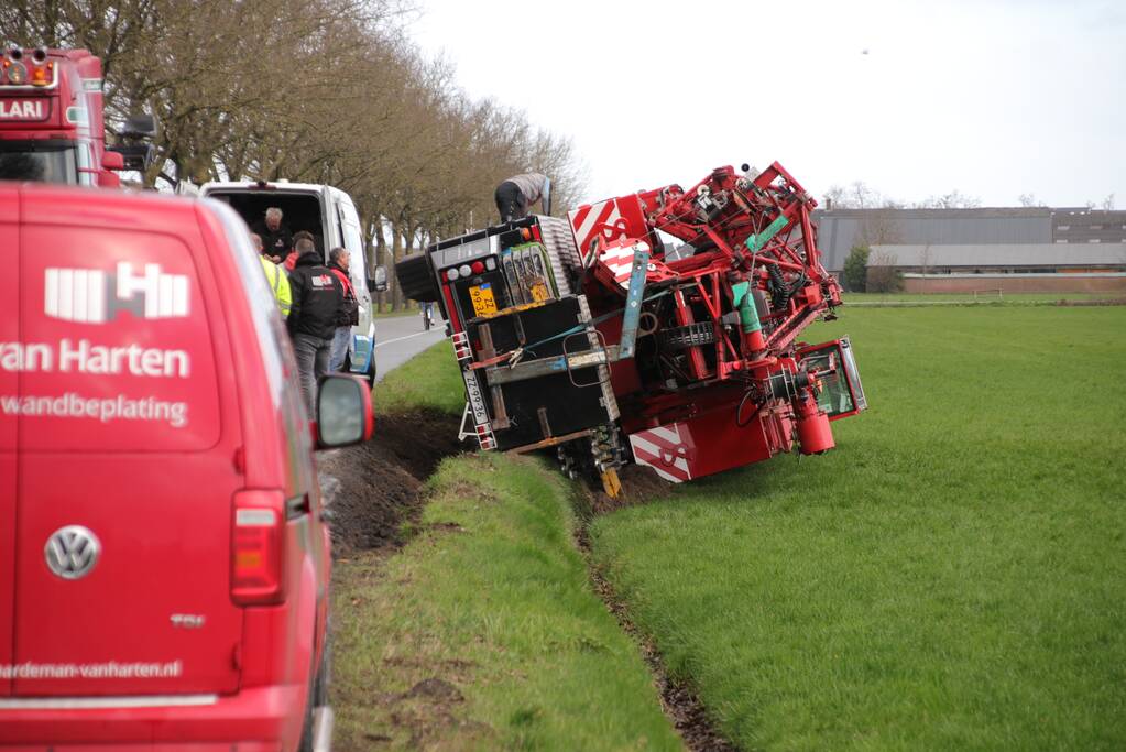Kraanwagen belandt in weiland