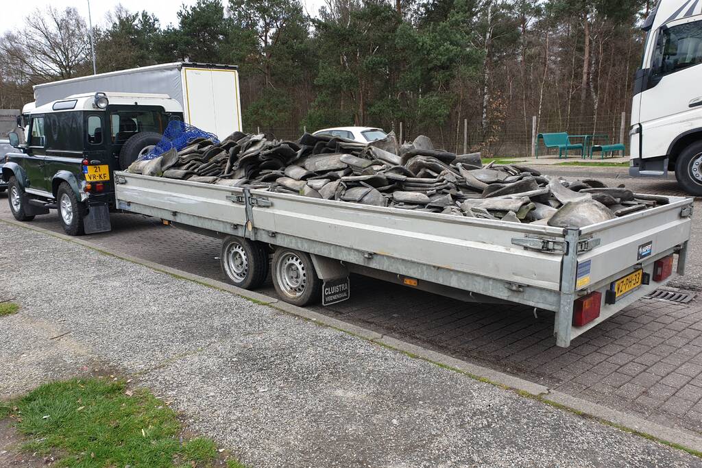 Auto met zware aanhanger dakpannen belandt in vangrail