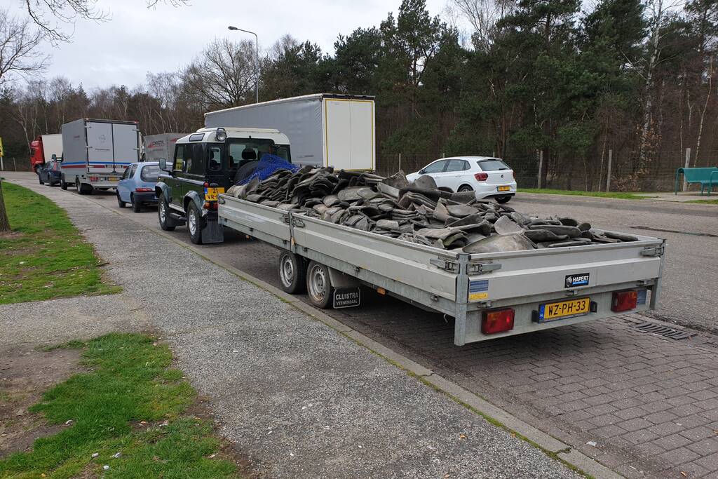 Auto met zware aanhanger dakpannen belandt in vangrail