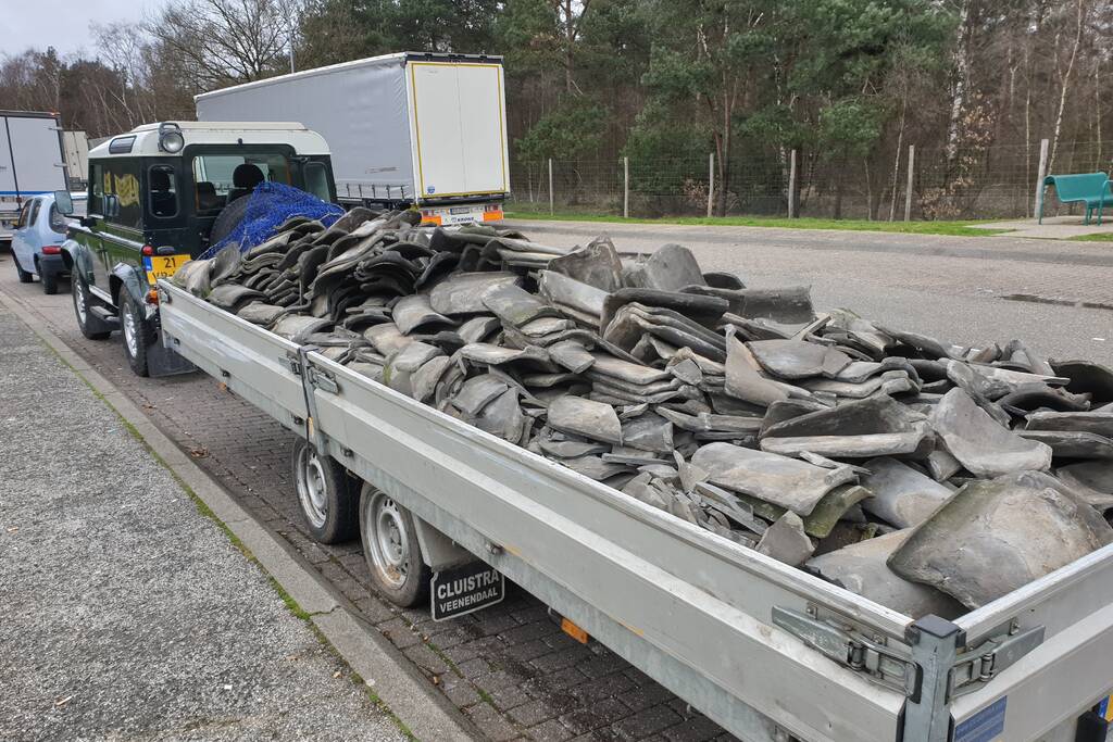 Auto met zware aanhanger dakpannen belandt in vangrail