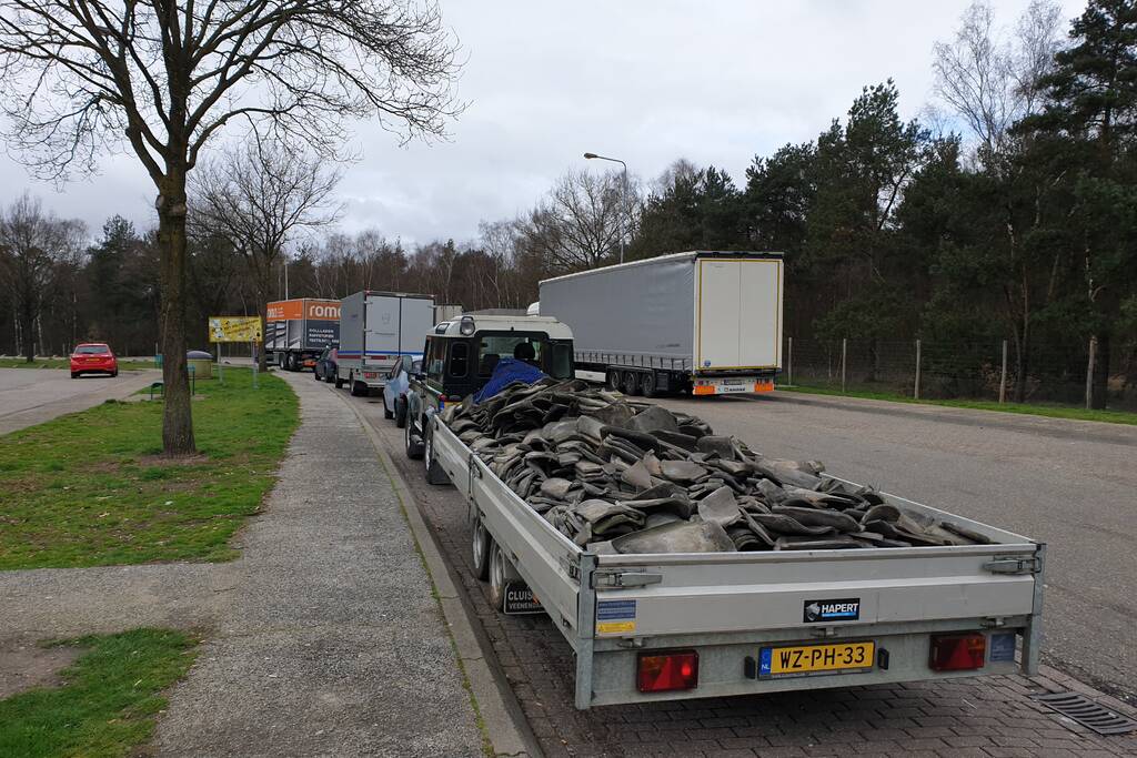 Auto met zware aanhanger dakpannen belandt in vangrail