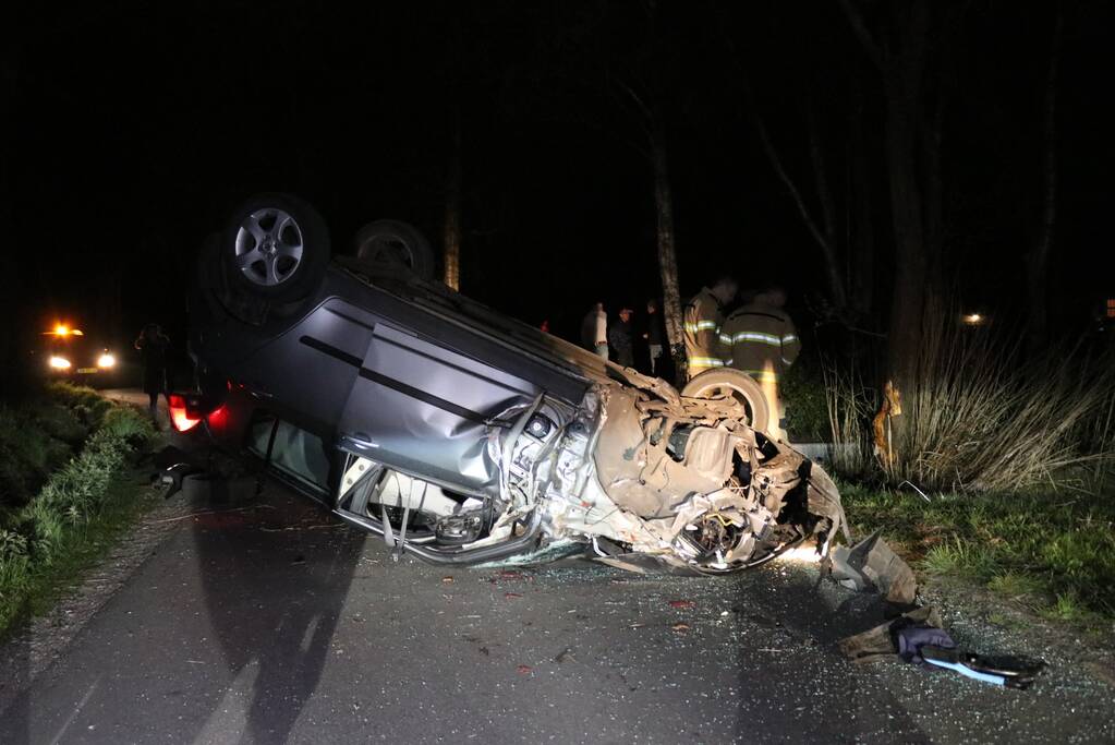 Auto beland op zijn dak na botsing met boom