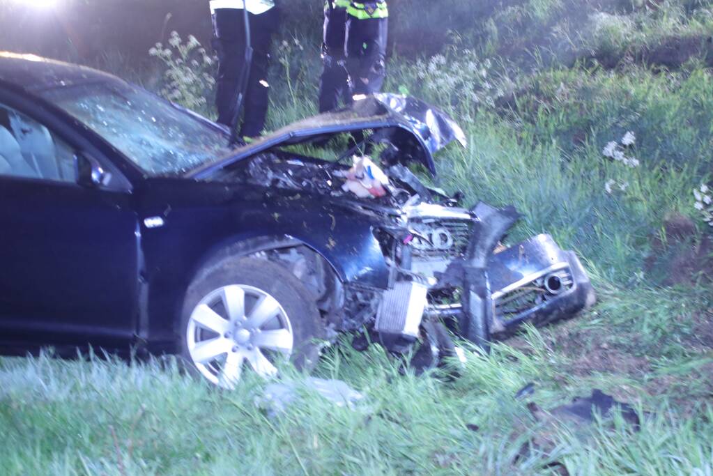 Auto belandt naast de snelweg