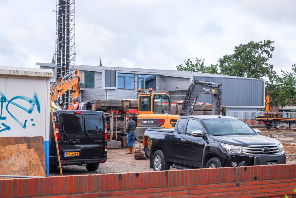 Vrachtwagen kantelt op bouwterrein