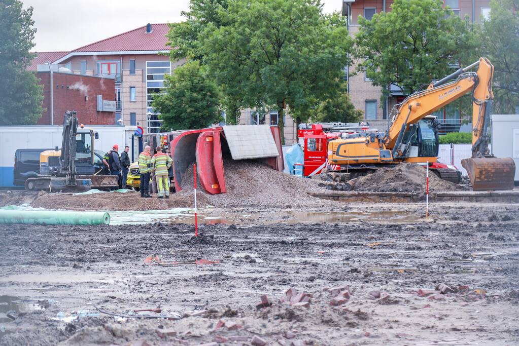 Vrachtwagen kantelt op bouwterrein