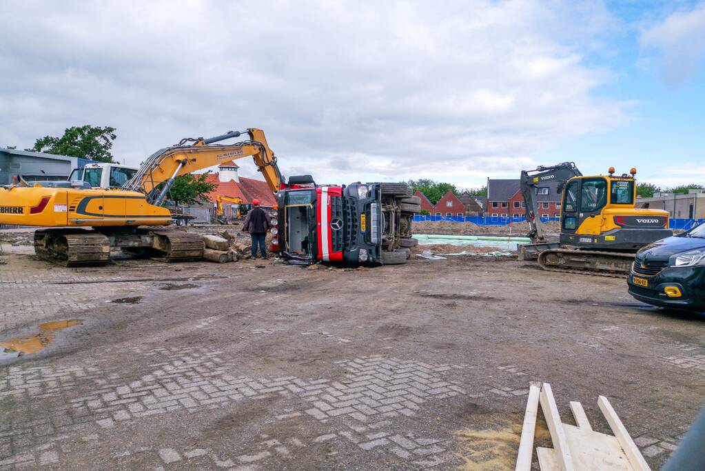 Vrachtwagen kantelt op bouwterrein