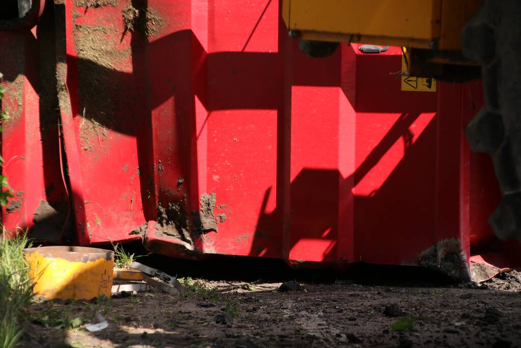 Kar met maai-afval achter trekker kantelt