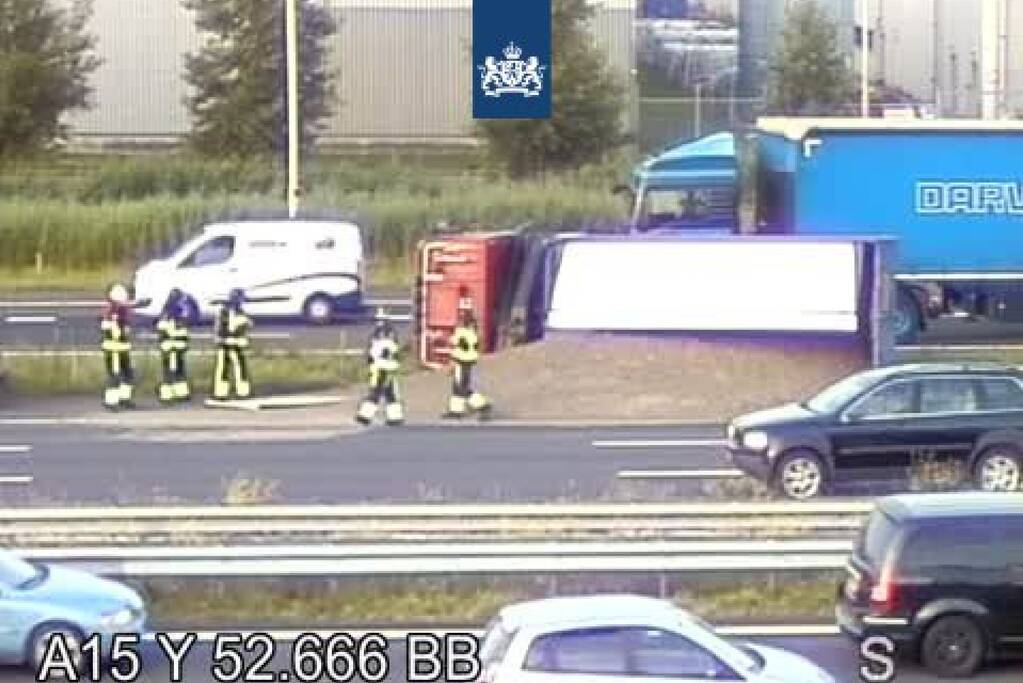 Vrachtwagen met zand kantelt op snelweg