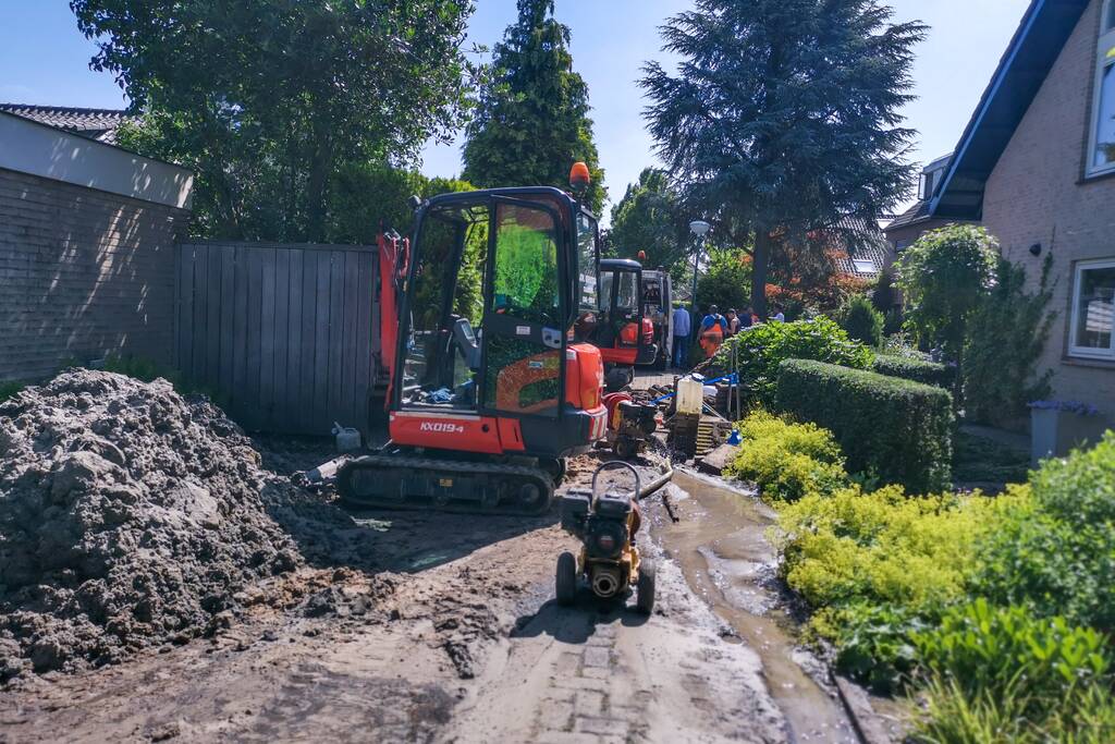 Smalle weg afgesloten door gesprongen waterleiding