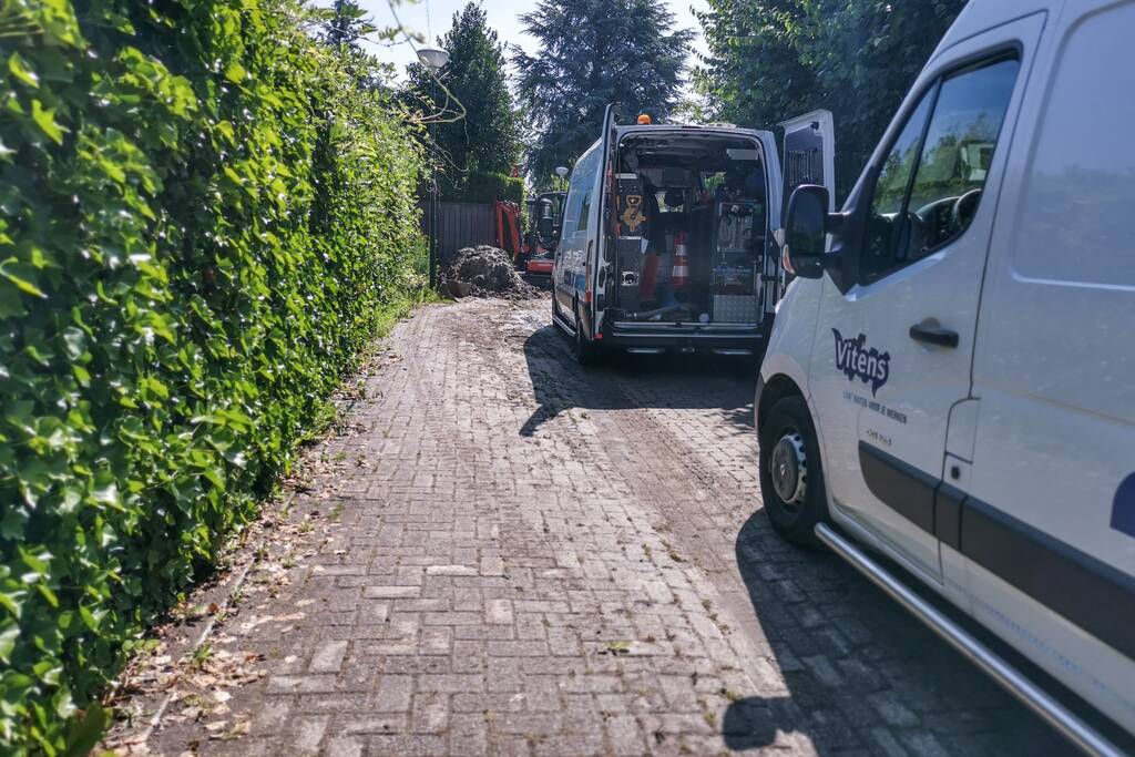 Smalle weg afgesloten door gesprongen waterleiding