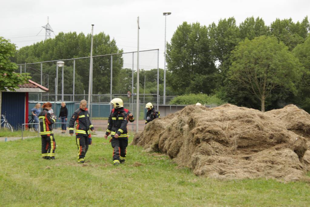 Brandweer blust smeulende hooibalen