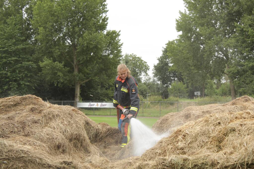 Brandweer blust smeulende hooibalen