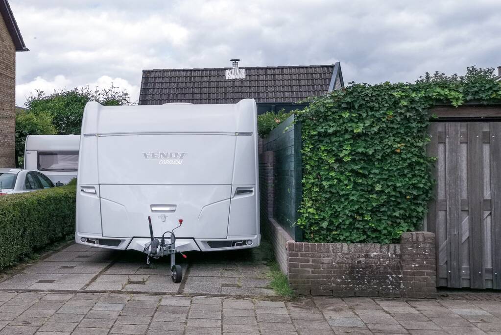 Man bekneld tussen caravan en muur