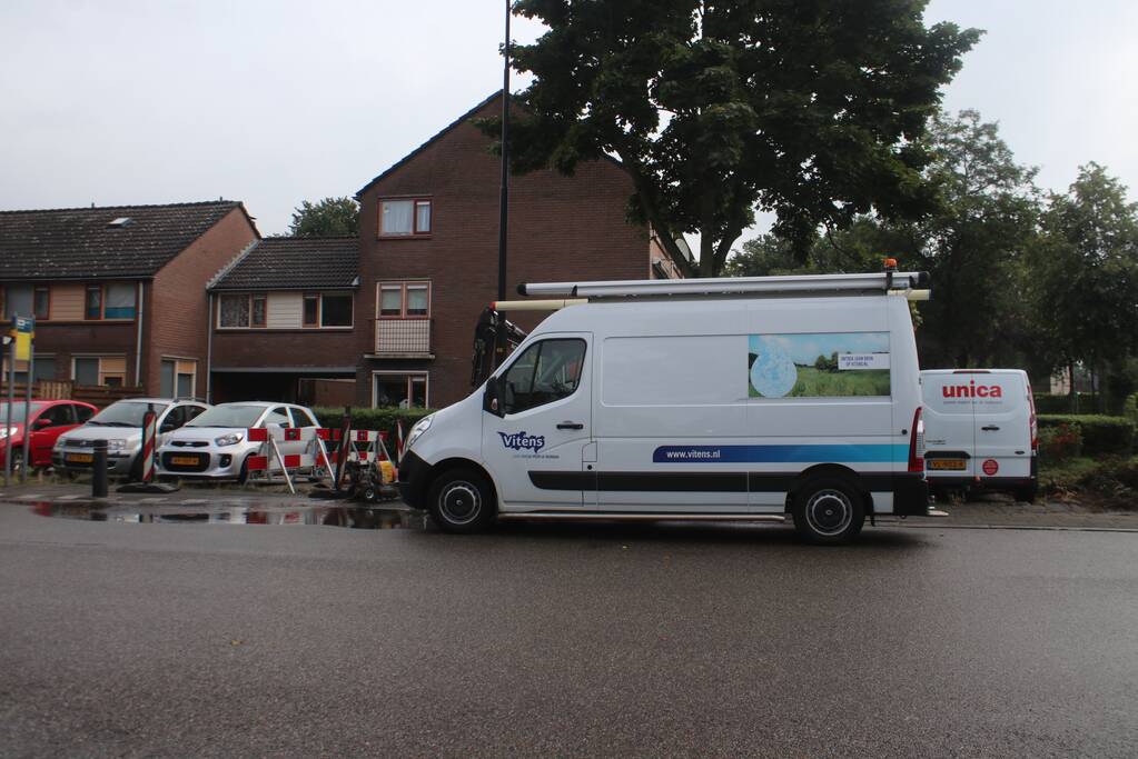 Gesprongen waterleiding onder bushalte