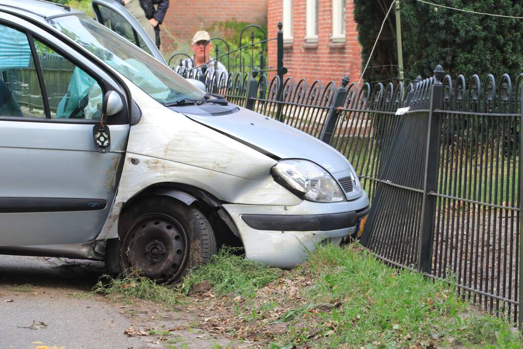 Auto rijdt tegen boom en klapt op hek