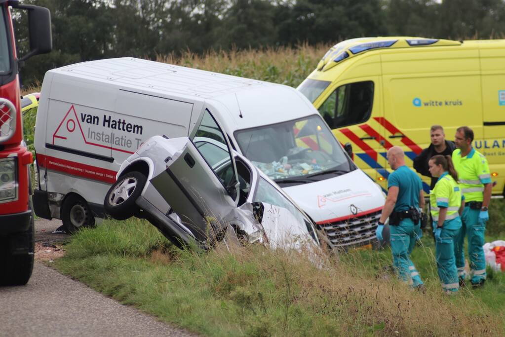 Bestelbus en auto belandt in greppel na botsing