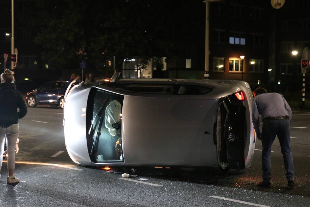 Auto belandt op zijkant na botsing; inzittende gewond bij reddingsactie