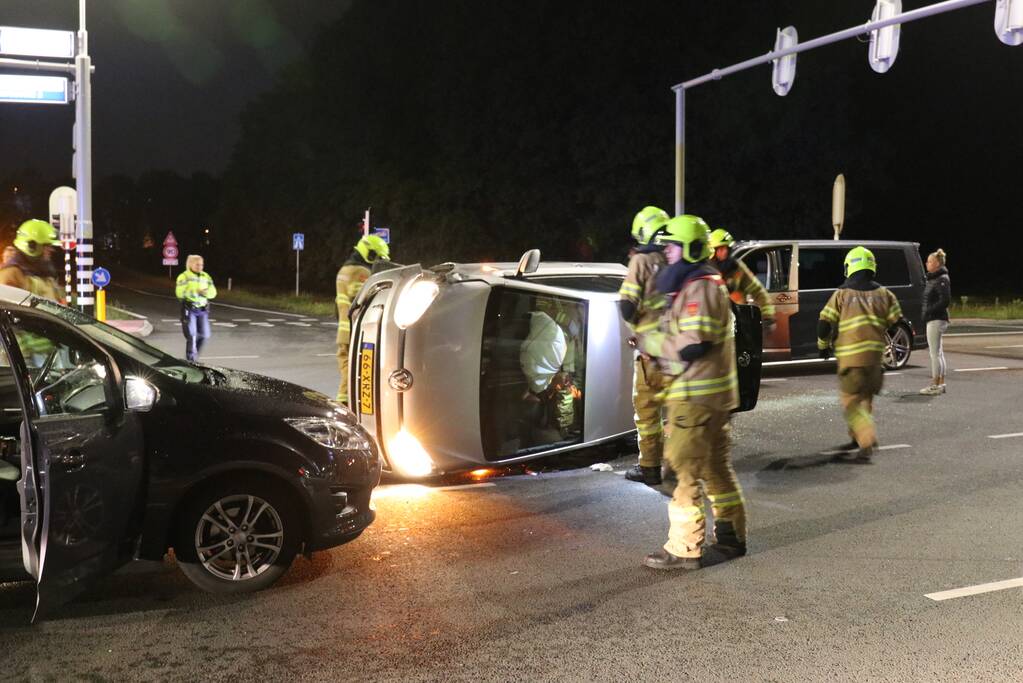 Auto belandt op zijkant na botsing; inzittende gewond bij reddingsactie