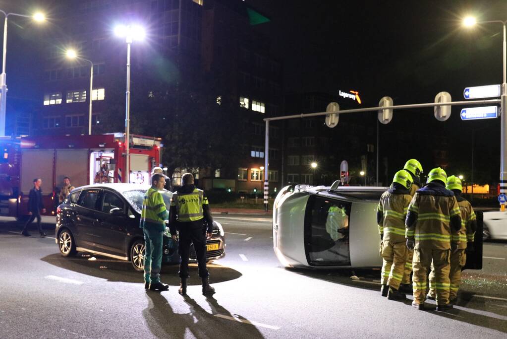 Auto belandt op zijkant na botsing; inzittende gewond bij reddingsactie