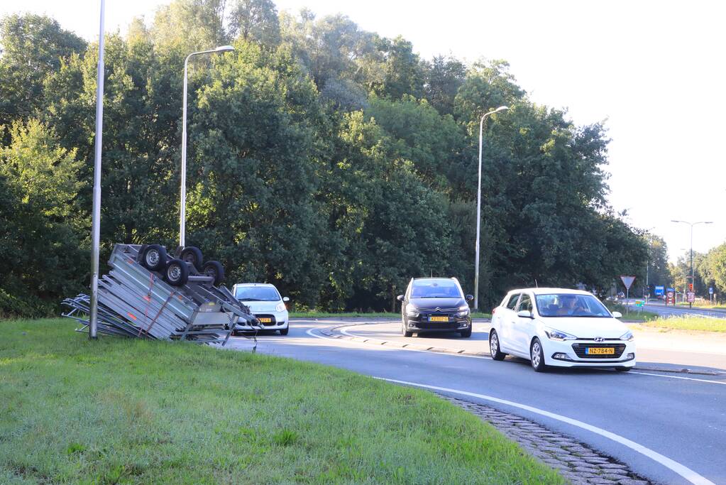 Aanhangwagen met steigerdelen kantelt