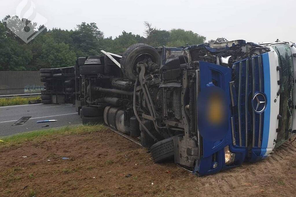 Rijbaan snelweg geblokkeerd door gekantelde vrachtwagen; filmende bestuurders bekeurd