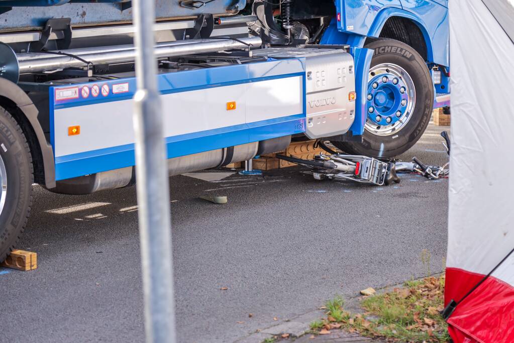 Afslaande vrachtwagen rijdt over fietsster