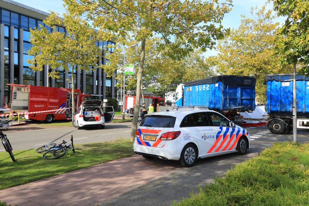 Afslaande vrachtwagen rijdt over fietsster