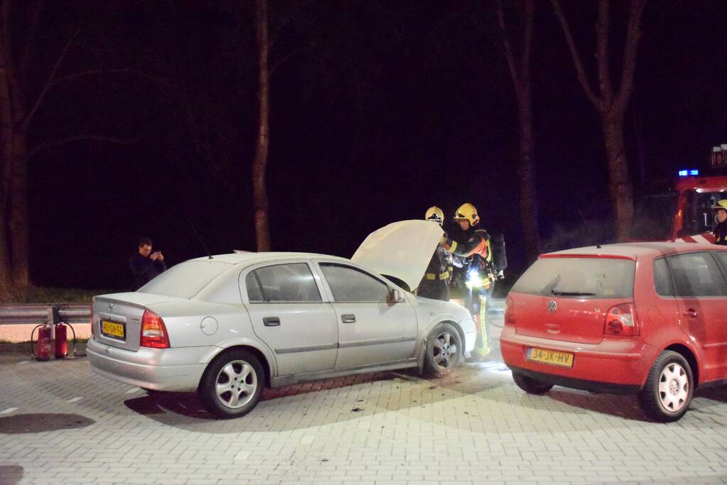 Omstanders blussen brandende auto