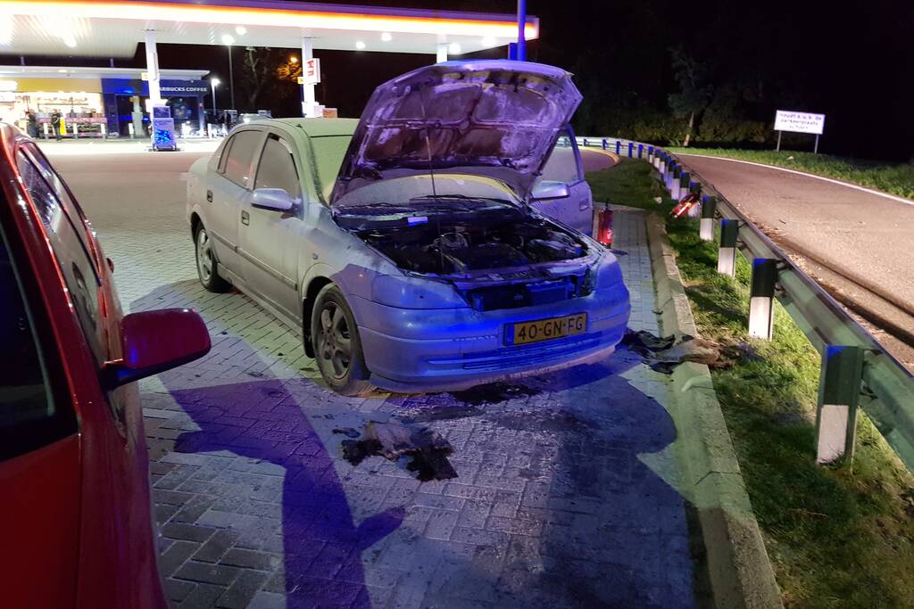 Omstanders blussen brandende auto