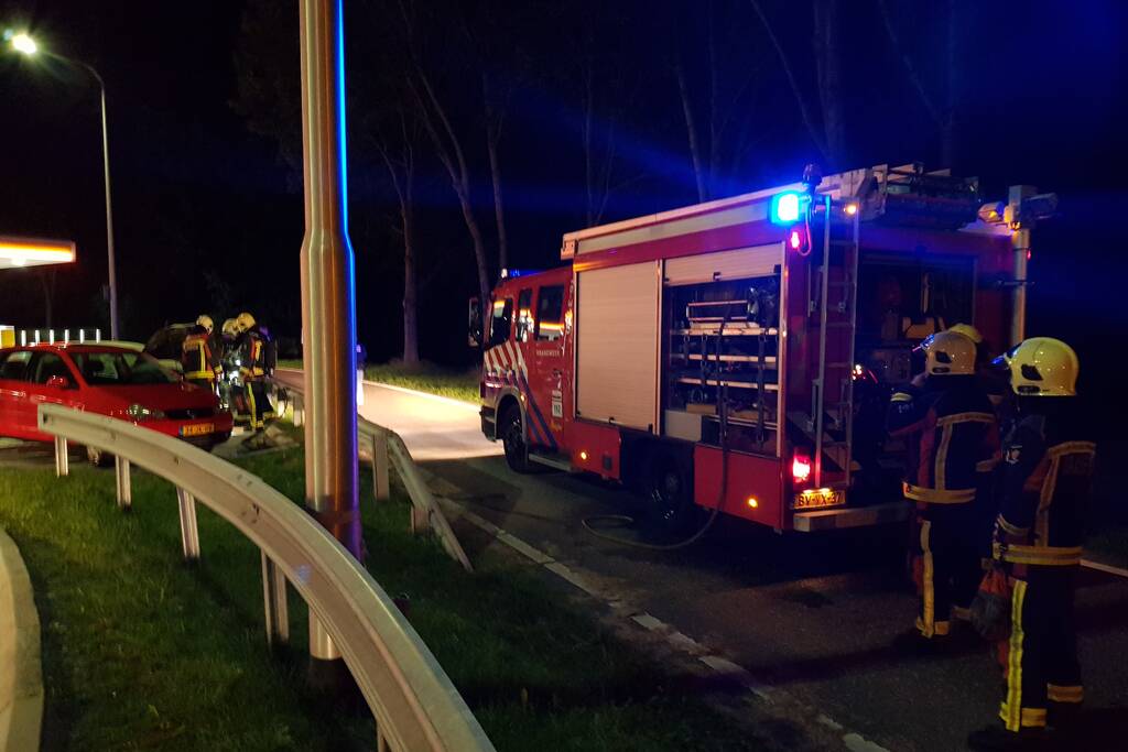 Omstanders blussen brandende auto