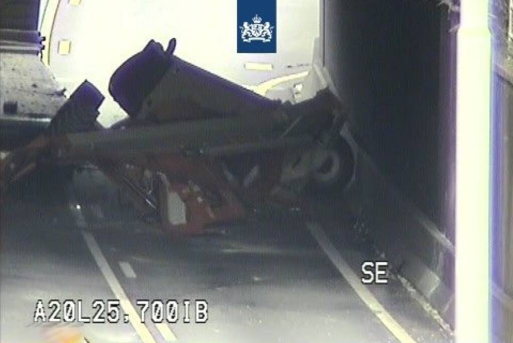 Vrachtwagen met hoogwerker klemgereden onder spoorviaduct