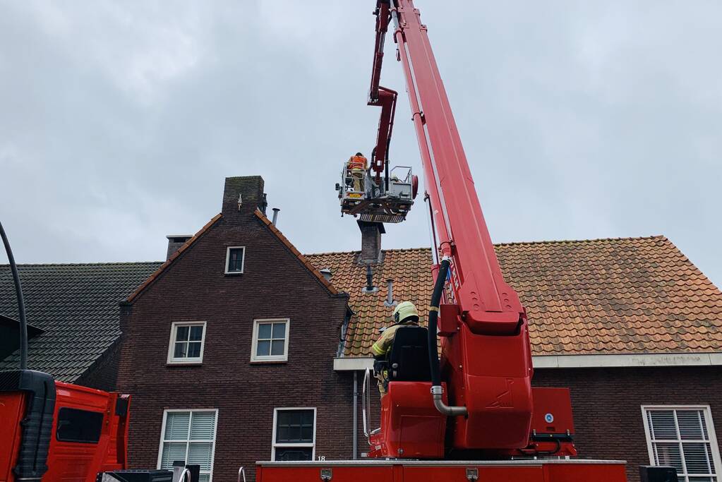 Brandweer veegt schoorsteen na brand