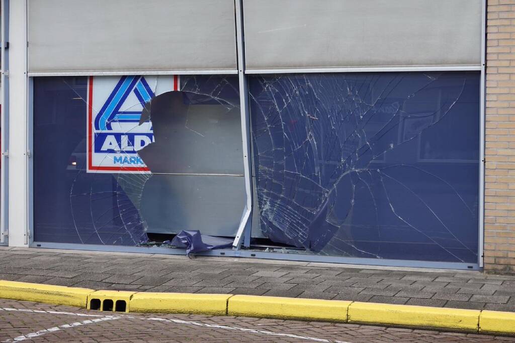 Achteruitrijdende auto ramt winkelpui Aldi-supermarkt