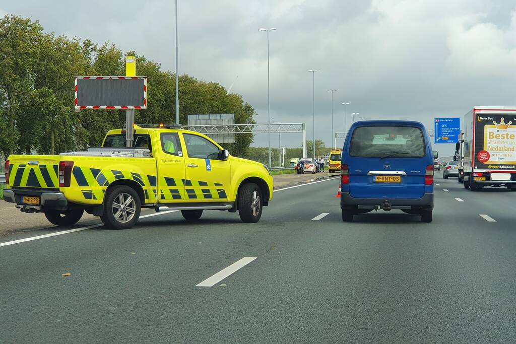 Auto over de kop naast snelweg