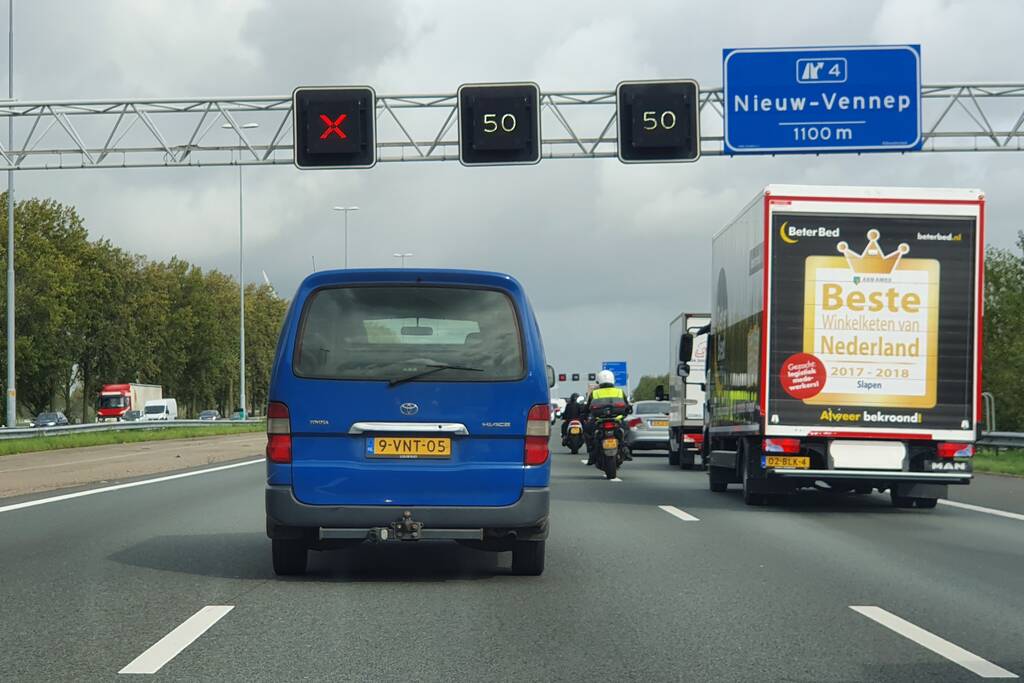 Auto over de kop naast snelweg