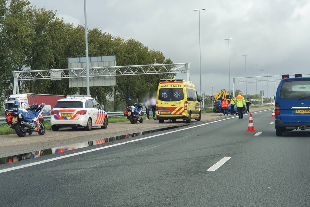 Auto over de kop naast snelweg