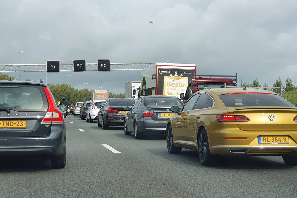 Auto over de kop naast snelweg