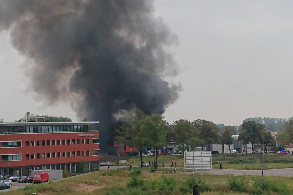 Auto in garagebedrijf in brand