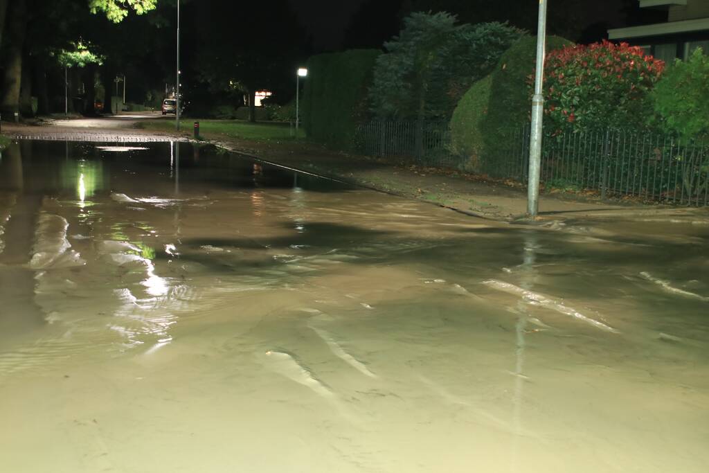 Straat blank door gesprongen waterleiding