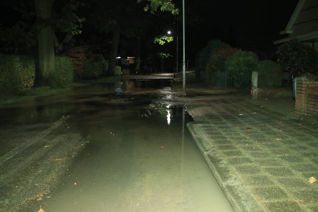 Straat blank door gesprongen waterleiding