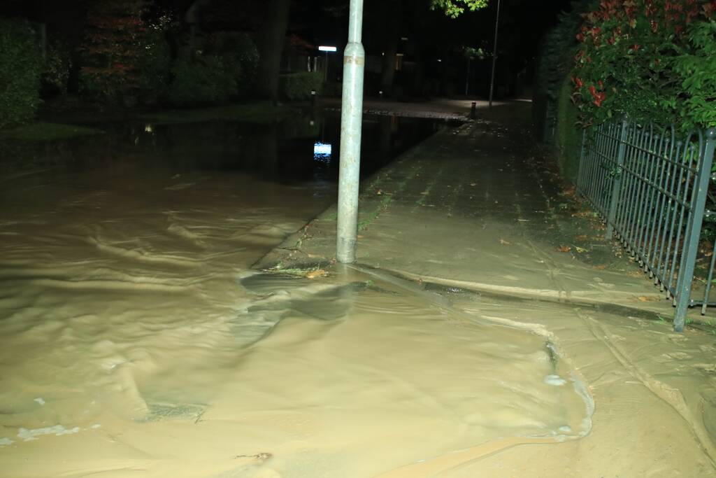 Straat blank door gesprongen waterleiding