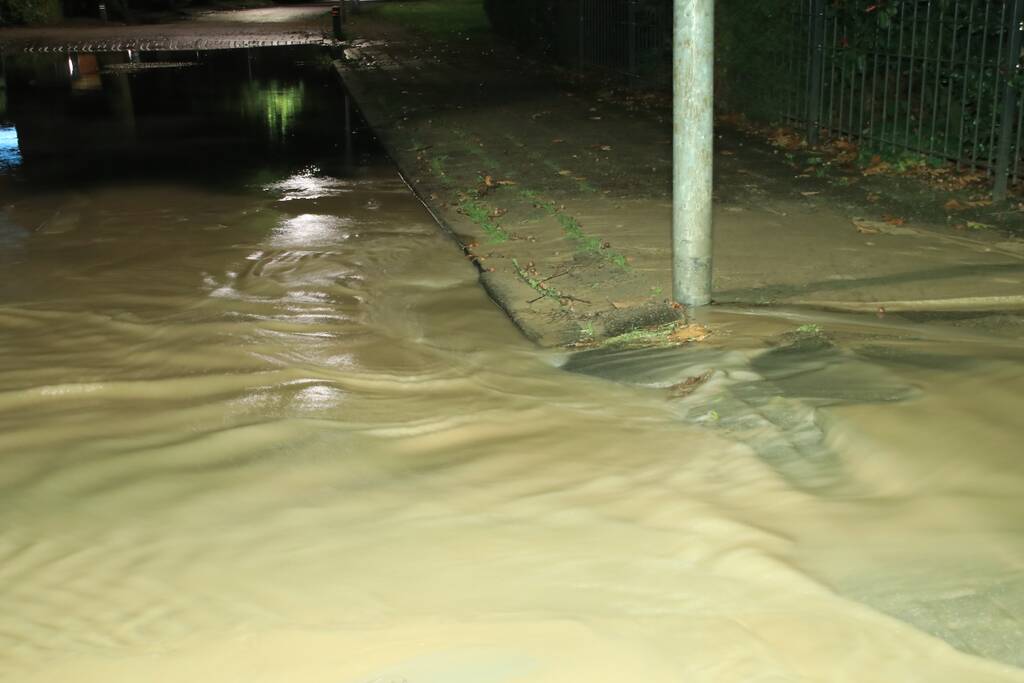 Straat blank door gesprongen waterleiding