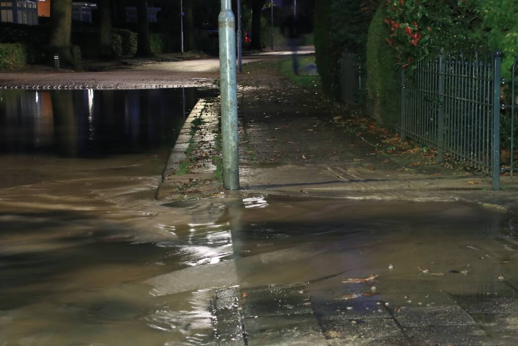 Straat blank door gesprongen waterleiding